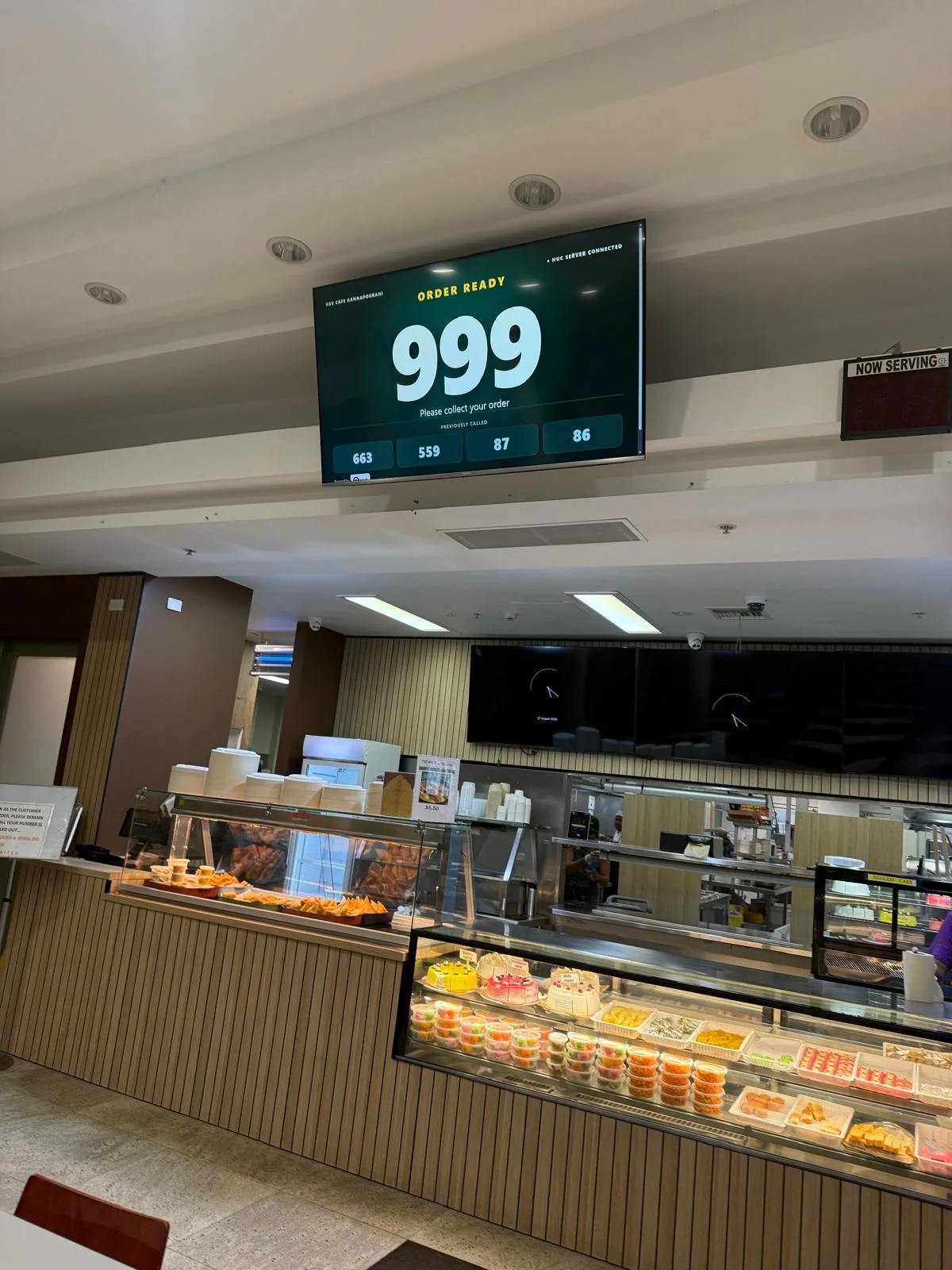 QRight order-ready display above a Melbourne restaurant counter showing the ready order and previously called numbers